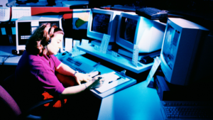 A 911 dispatch operator answering calls in front of computers.