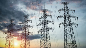 Electrical towers in front of a sunset.