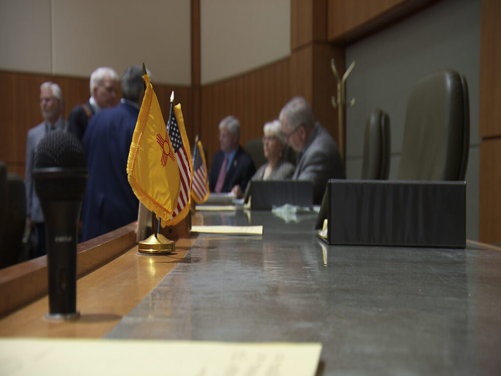 A group of people sitting at a table in a courtroom.