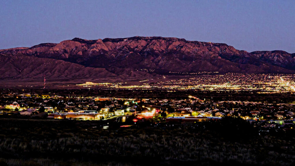 The Sandia mountains at sundown with the city lights.