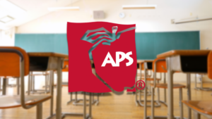 The aps logo is in the middle of a classroom.