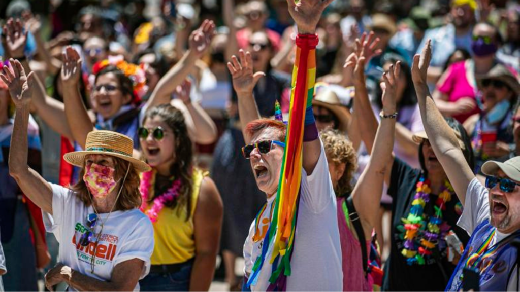 A group of people in a parade with their hands raised.