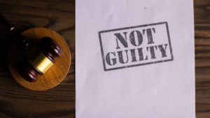 A not guilty stamp on a piece of paper on a wooden table.