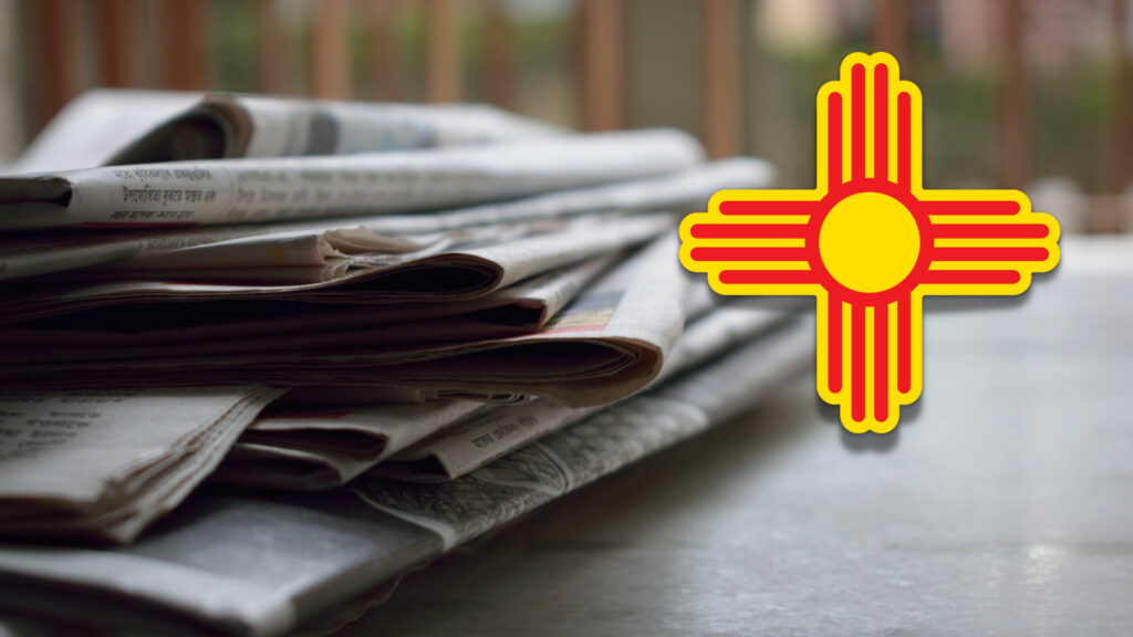 A pile of newspapers with the new mexico flag on top.