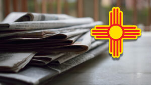 A pile of newspapers with the new mexico flag on top.