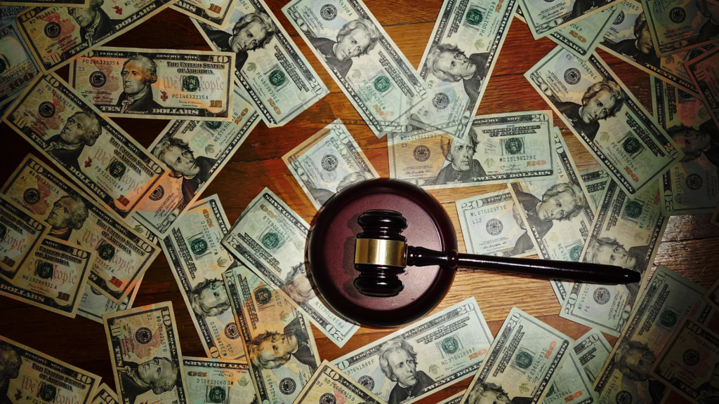 A gavel sits on top of a pile of money.