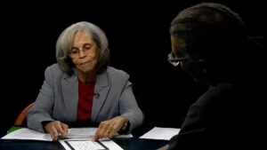 A man and woman sitting at a table with papers in front of them.