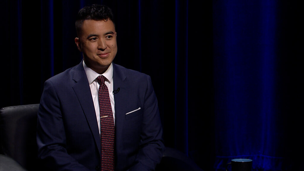 A man in a suit sitting in a chair.