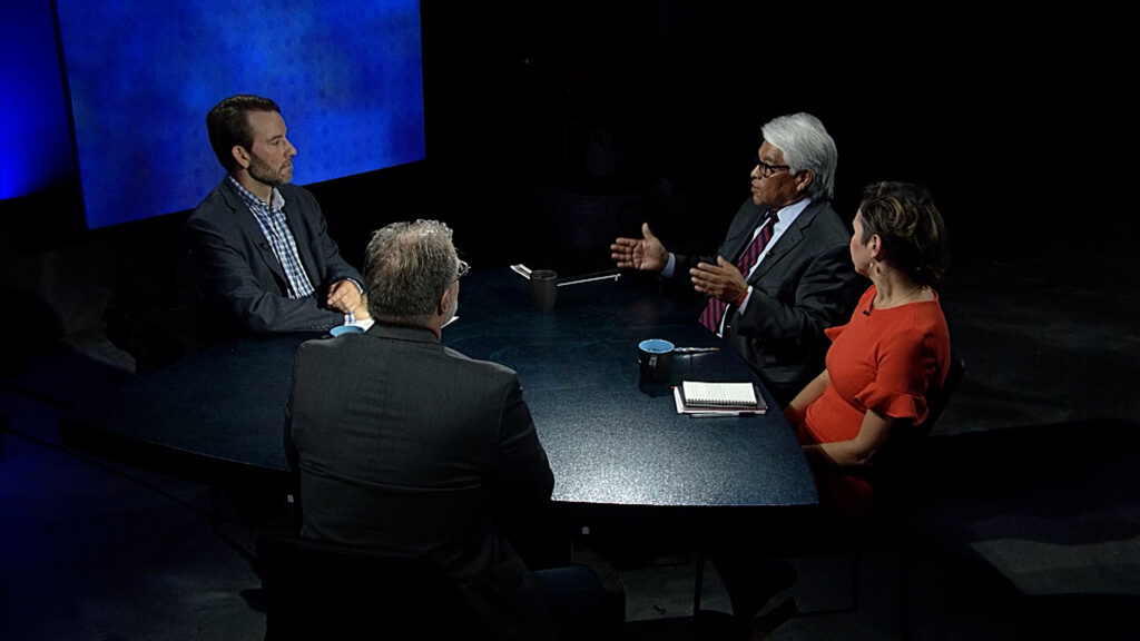 A group of people sitting around a table talking.