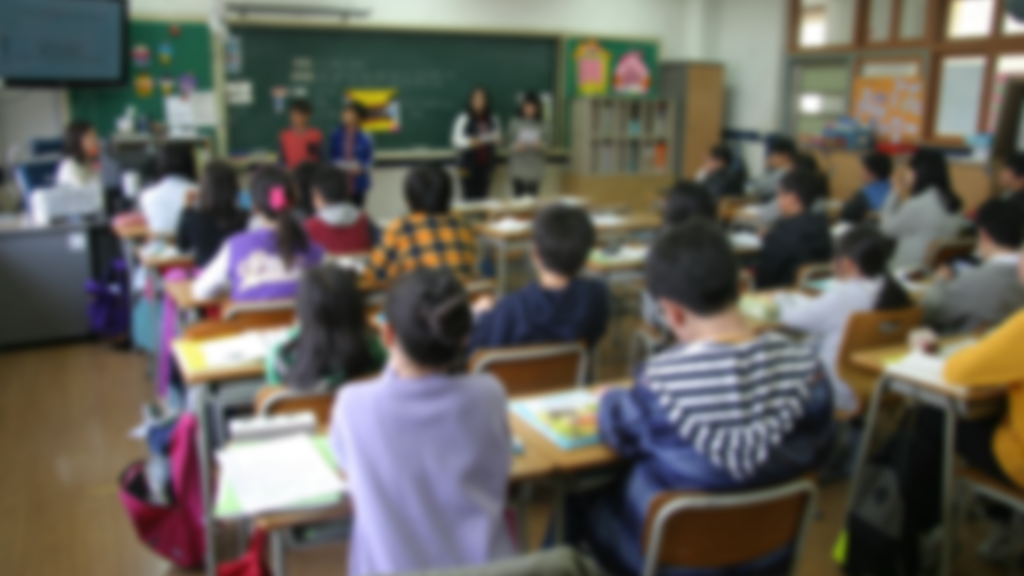 A classroom with many students sitting at desks.