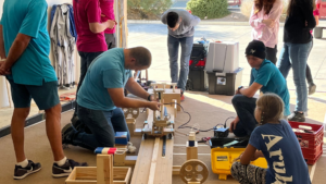 A group of people working on a wooden project.