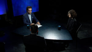 Two people sitting at a table in a dark room.