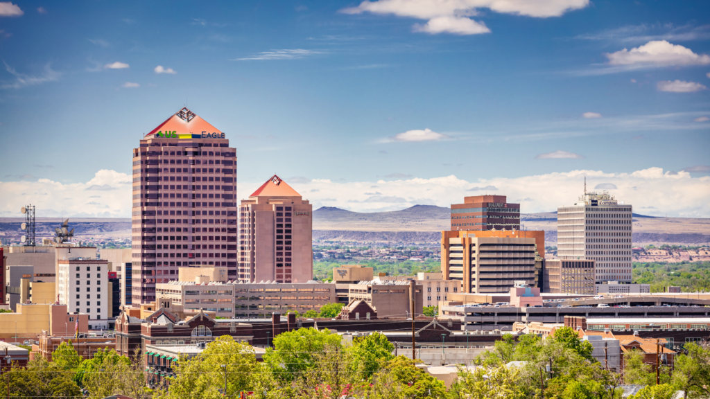 A city skyline with trees and mountains in the background.