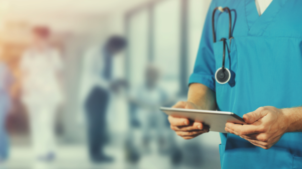 A nurse is holding a tablet in front of a group of people.