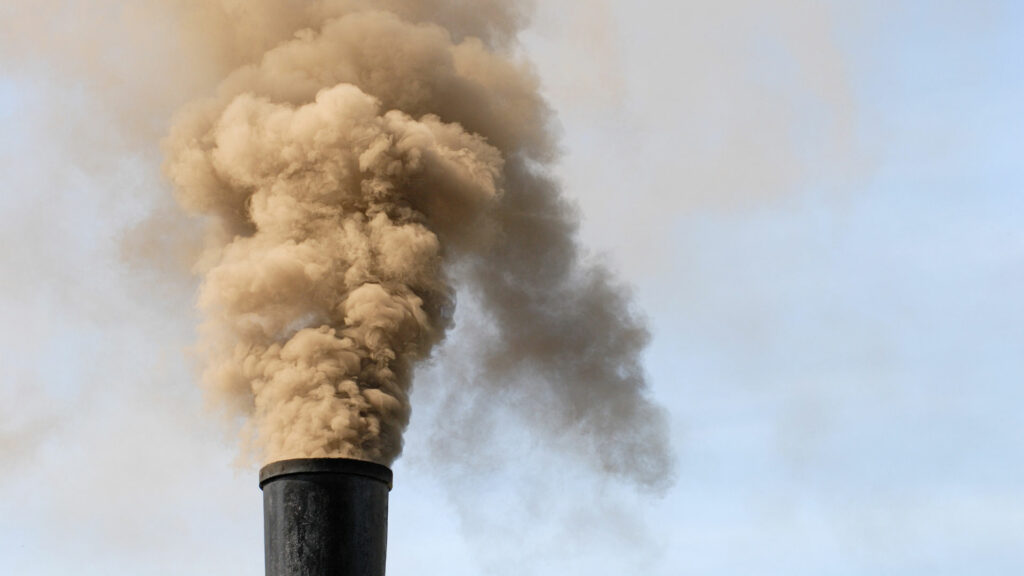 A black smoke billowing out of a chimney.