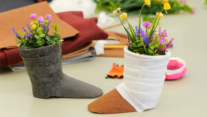 A pair of boots with flowers in them on a table.