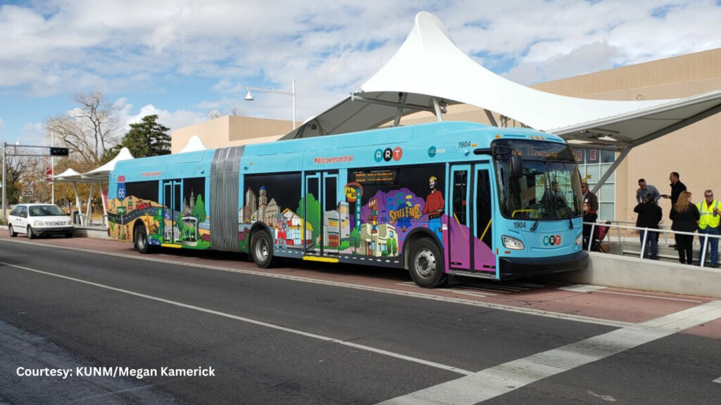 A colorful bus is parked in front of a building.