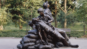 A bronze statue of a man and a woman on top of a pile of rocks.