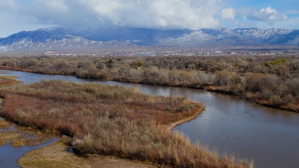 An aerial view of a river with mountains in the background.