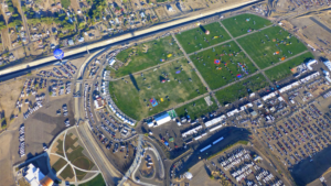 An aerial view of a park with a lot of cars.