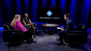 A group of people sitting in chairs in front of a tv.