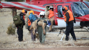 A group of people standing next to a helicopter.