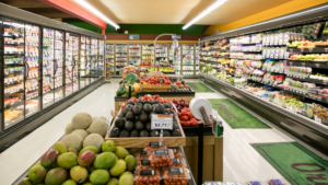 A well-stocked grocery store aisle featuring fresh produce and refrigerated items.