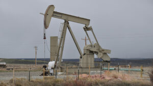 Oil pumpjack in operation in a rural landscape.