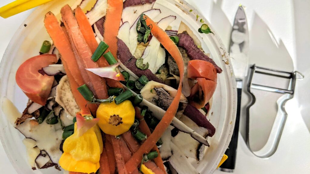 A colorful salad with various vegetables and a knife on the side, seen from above.