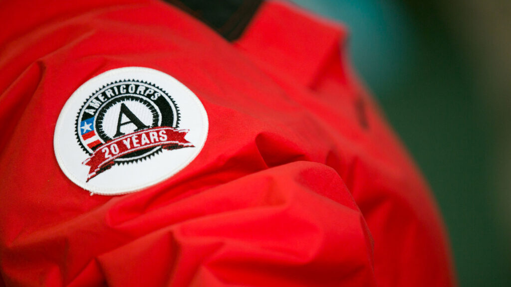 Close-up of a red jacket featuring an AmeriCorps 20 Years patch.