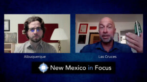 Two men participate in a virtual interview on "New Mexico in Focus," with labels indicating they are in Albuquerque and Las Cruces.