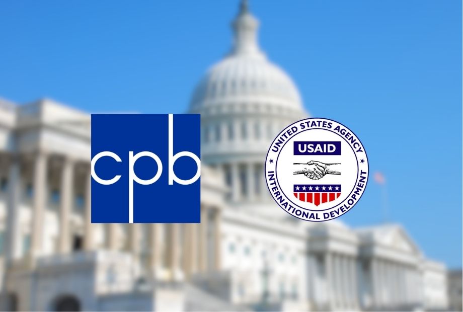 Logos of the Corporation for Public Broadcasting and USAID displayed in front of a blurred image of the U.S. Capitol building.