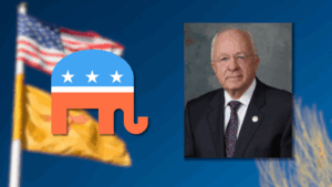 A portrait of an older man in a suit next to a Republican Party elephant logo, with blurred American and New Mexico flags in the background.
