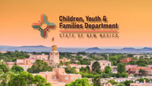 Logo of the Children, Youth & Families Department, State of New Mexico, over a blurred cityscape with southwestern-style buildings at sunset.