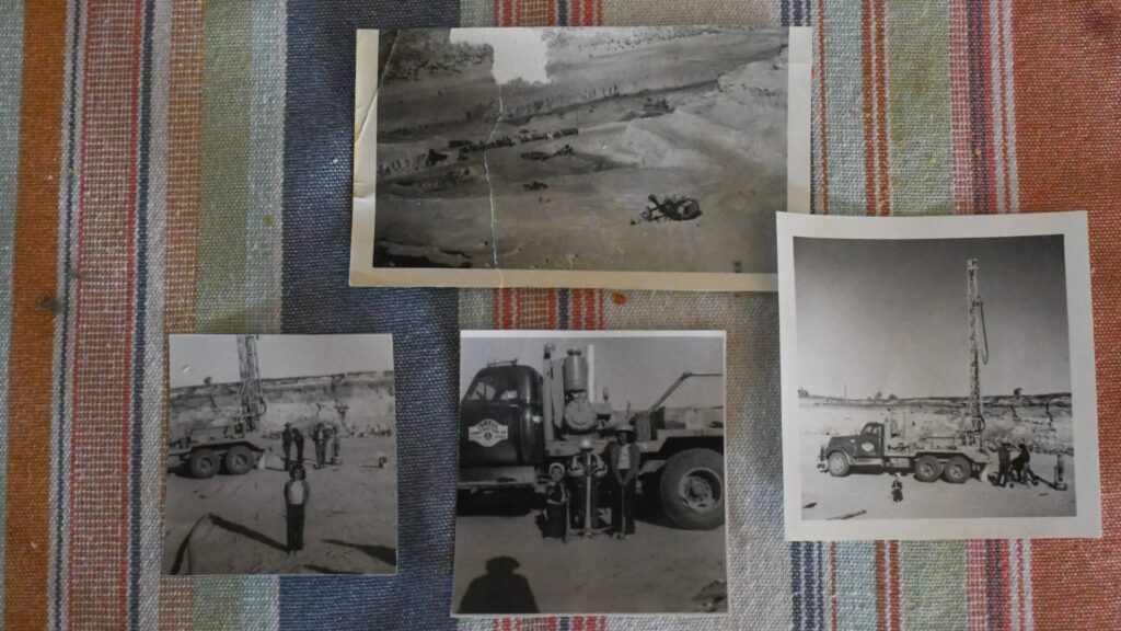 Four black-and-white photos of drilling trucks and workers at a construction or excavation site, arranged on a striped fabric background.