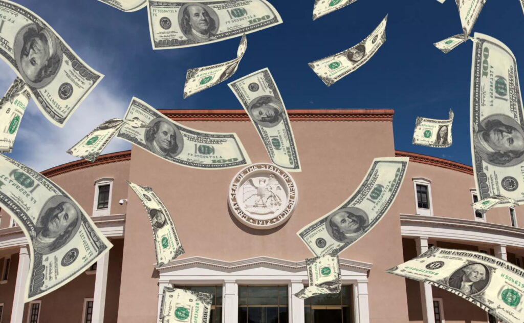 U.S. dollar bills falling in front of a government building with a blue sky in the background.