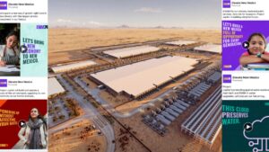 Aerial view of a large industrial complex in a desert landscape, with several rectangular buildings, roads, and infrastructure surrounded by arid terrain.