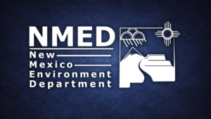 Logo of the New Mexico Environment Department with stylized mountains, clouds, a sun symbol, and bold white text on a dark blue textured background.