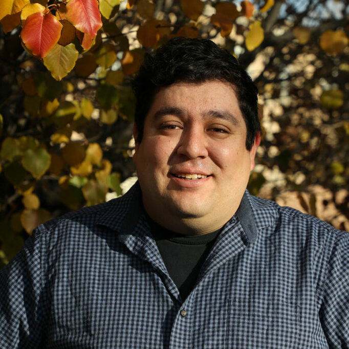 Antonio-Sanchez-photo A man smiling in front of a tree.