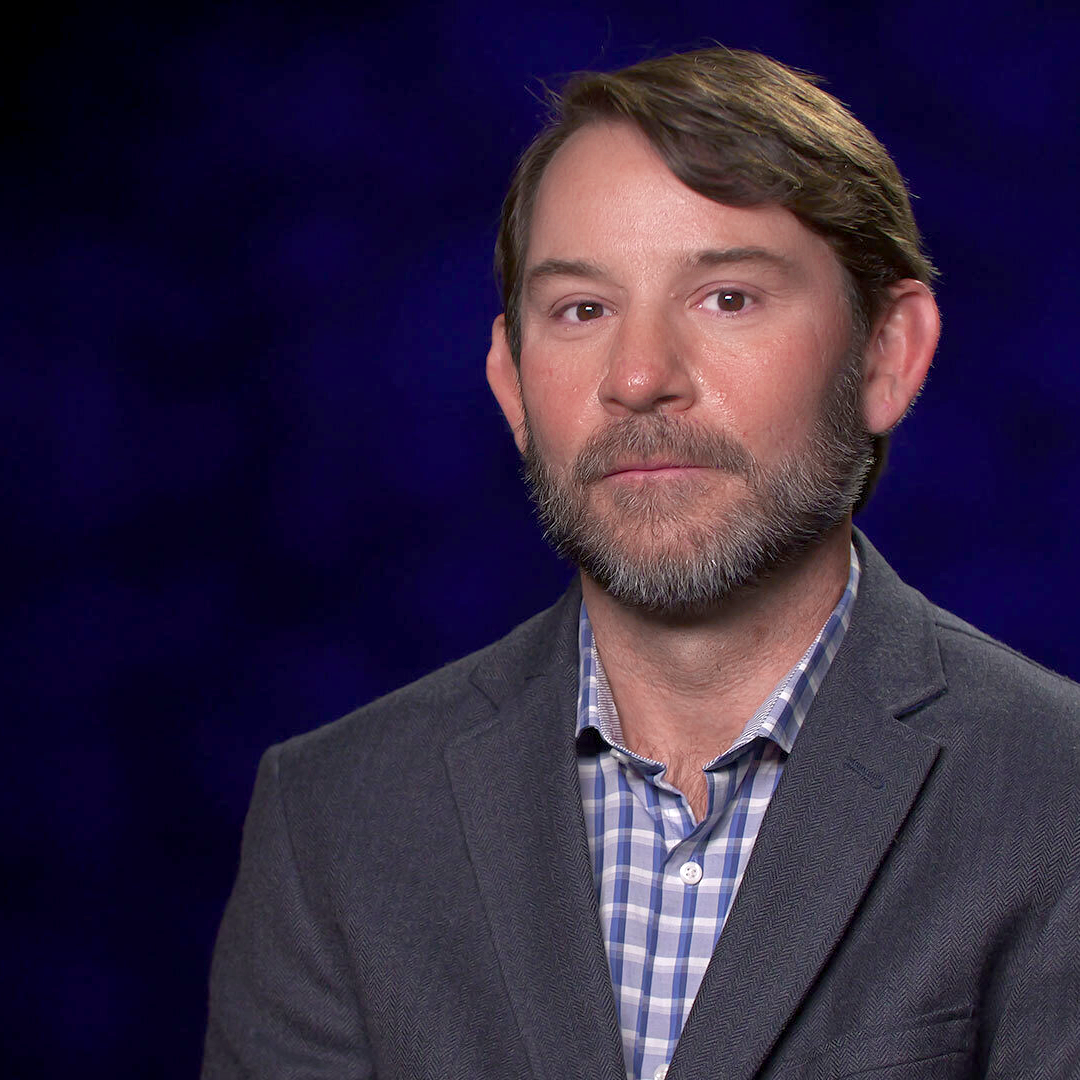 Jeff-Proctor-Pic A man with a beard in front of a blue background.