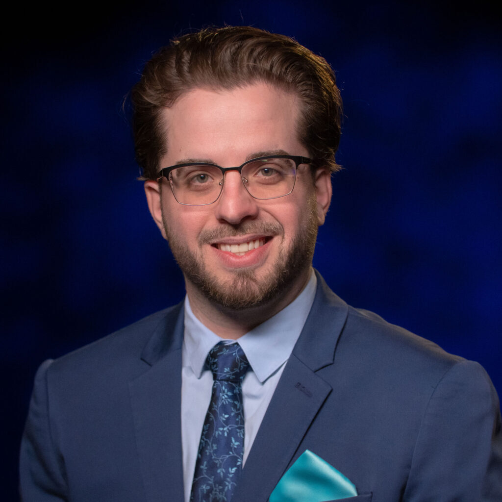 A man wearing glasses and a blue tie.