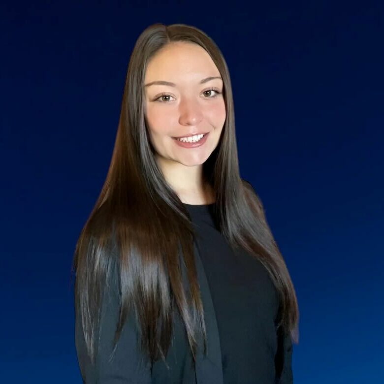 PhotoRoom_20230918_120458 A woman with long hair standing in front of a blue background.