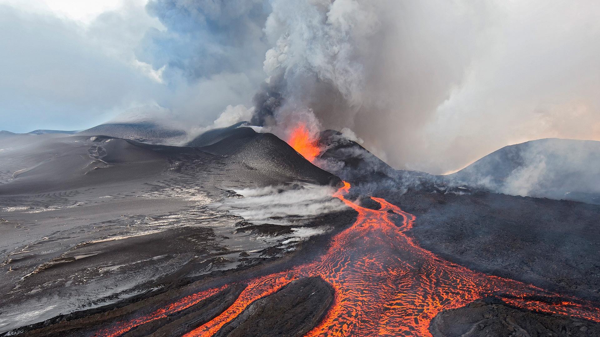 A volcano eruption, with molten lava trickling down it.