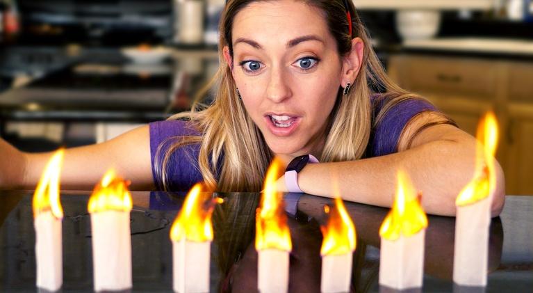 physics_girl A woman watches several sticks on fire.